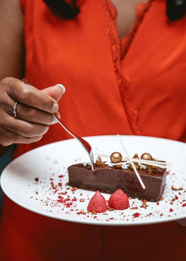 Boutique Hotel Texel De Cocksdorp  Eksteriør bilde A server cutting a piece of chocolate cake